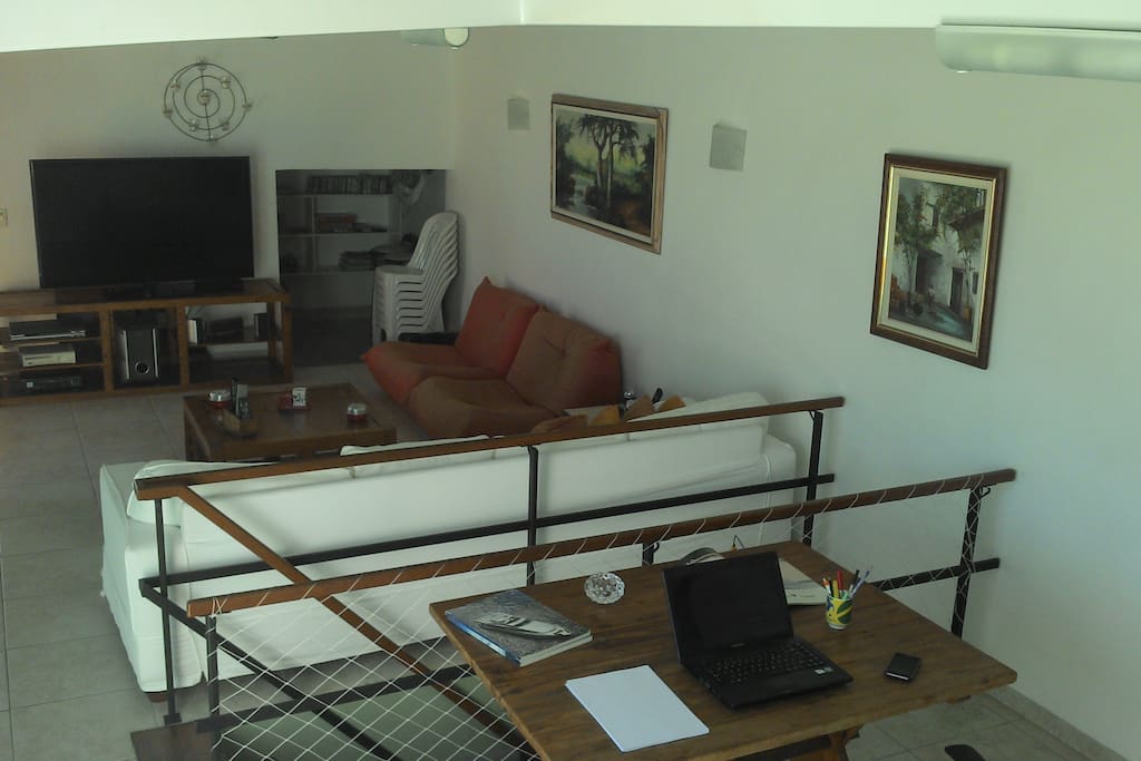 Salas com TV, sofas e amplo espaço para trabalho e lazer