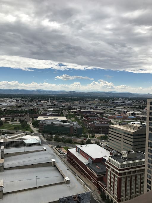 The view from the 33rd floor balcony of the mountains and Mile High, overlooking Univ of Colorado and Metropolitan State