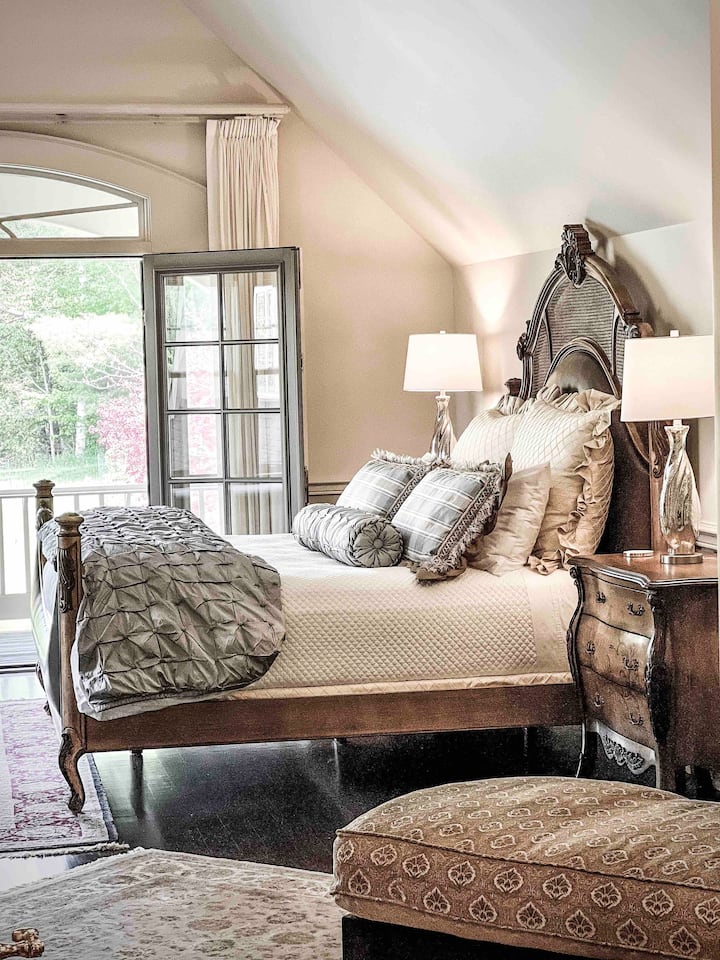 Suite de chambre principale de niveau supérieur avec lit de jour + balcon donnant sur le terrain, salon élégant, pépinière attenante et vaste placard.