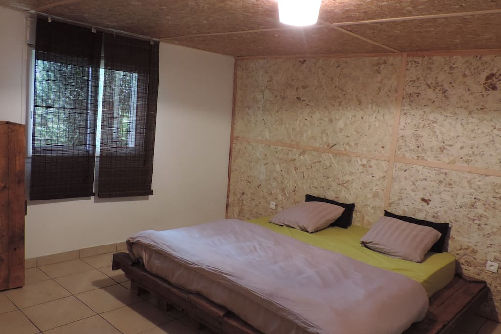 Chambre avec lit king size, lit fait main en palettes