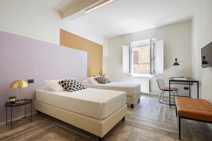 חדר שינה רפאלו עם שתי מיטות יחיד או מיטת קינג סייז אחת ושולחן