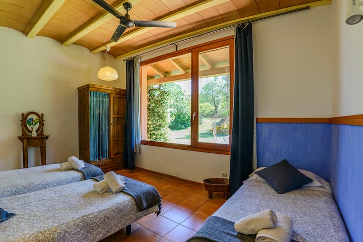 ห้องพักพร้อมเตียงเดี่ยว 3 หลังที่มองเห็นสวน