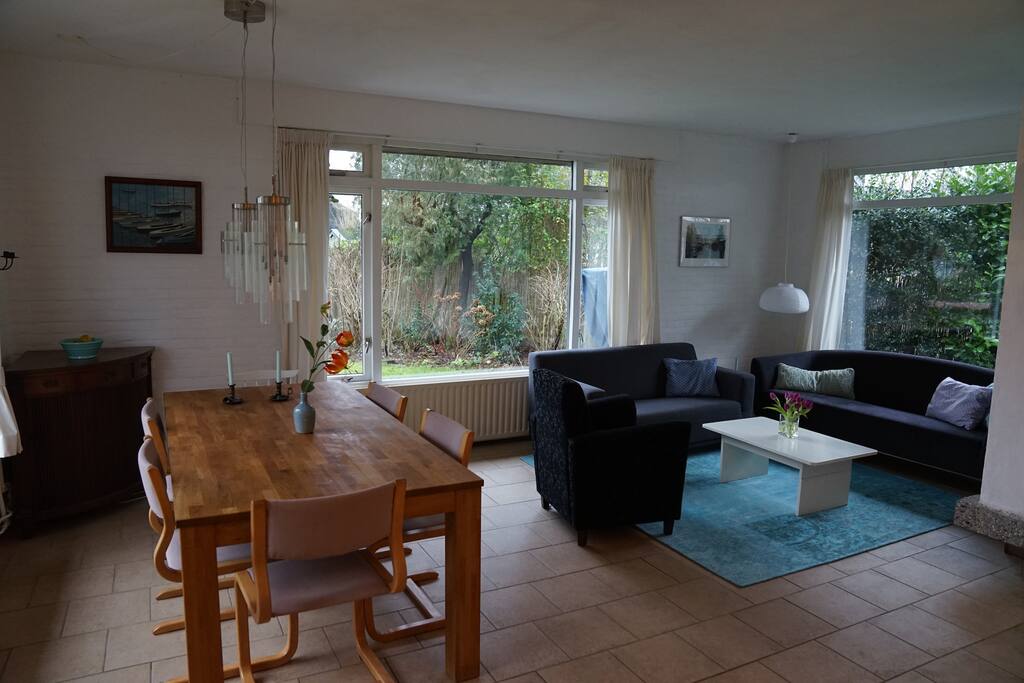 Onze ruime woonkamer met zithoek en open haard en een grote eettafel