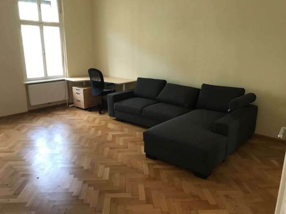 Wohnzimmer mit Couch und Arbeitsecke