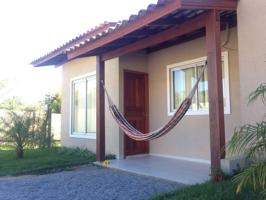 Varanda com rede e jardim.