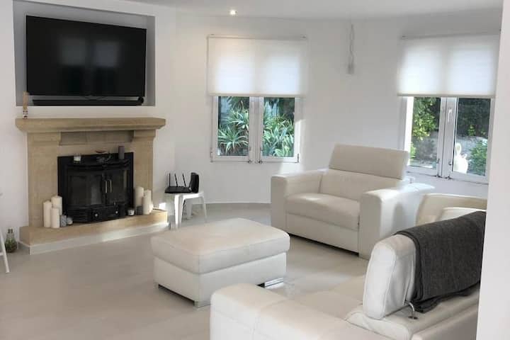 美丽的开放式休息室，在豪华皮革沙发上放松身心，配备壁炉和55英寸智能电视