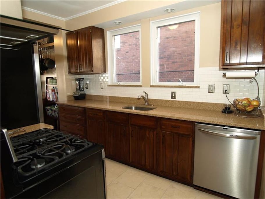 Fully equipped kitchen with gas range, dishwasher, and all cooking tools.