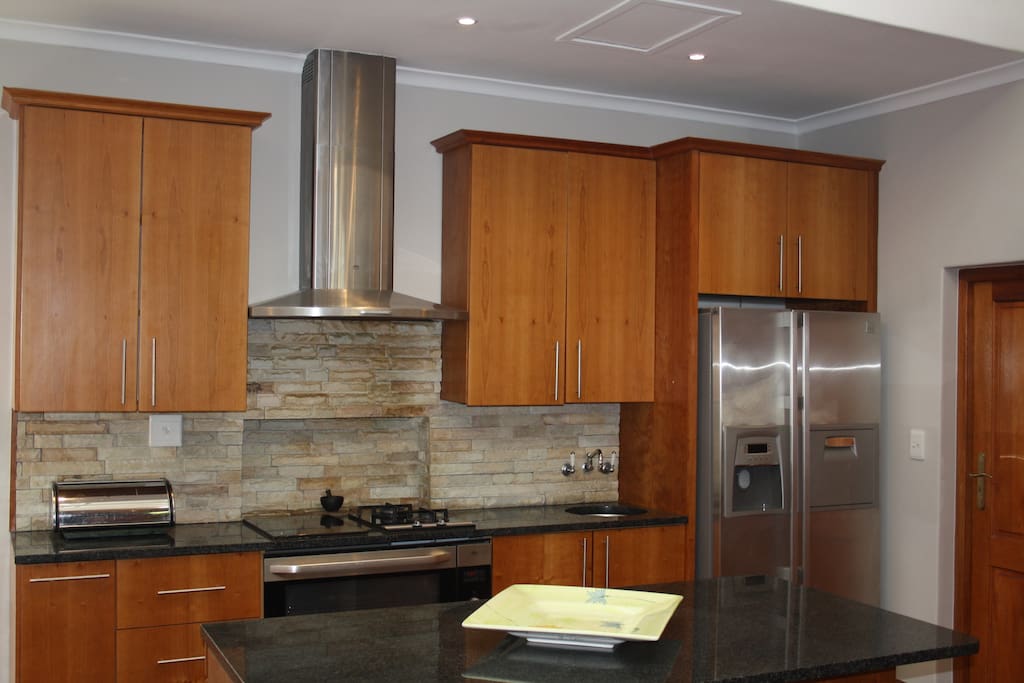 Open plan kitchen - oven, air vent, gas cookers, ice maker fridge, microwave