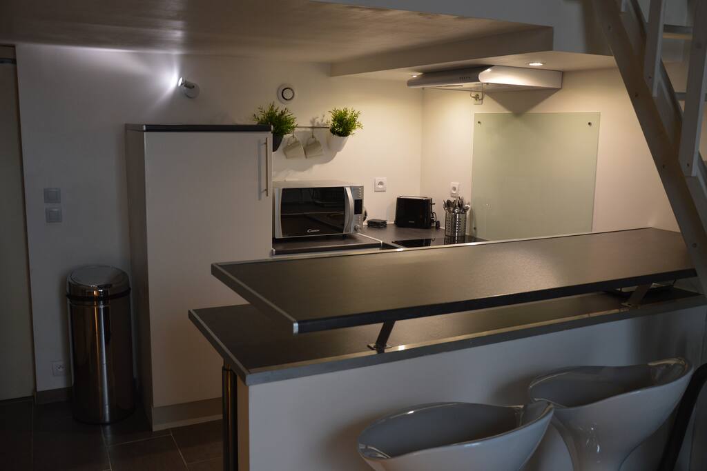 Cuisine équipée, ouverte sur le salon avec bar et tabourets