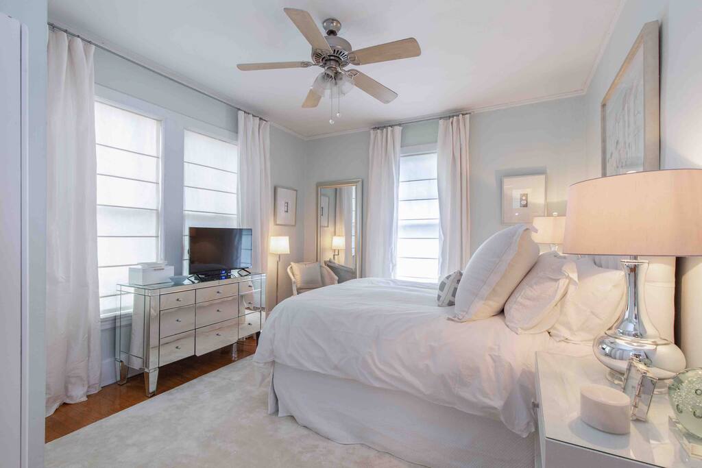 Bedroom with extremely comfy queen bed, down comforter, memory foam mattress, down pillows, television, and ceiling fan.