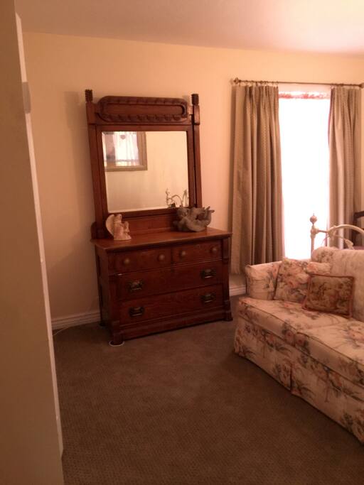 Antique dresser and mirror, a very comfortable loveseat rest on new luxurious
carpeting.