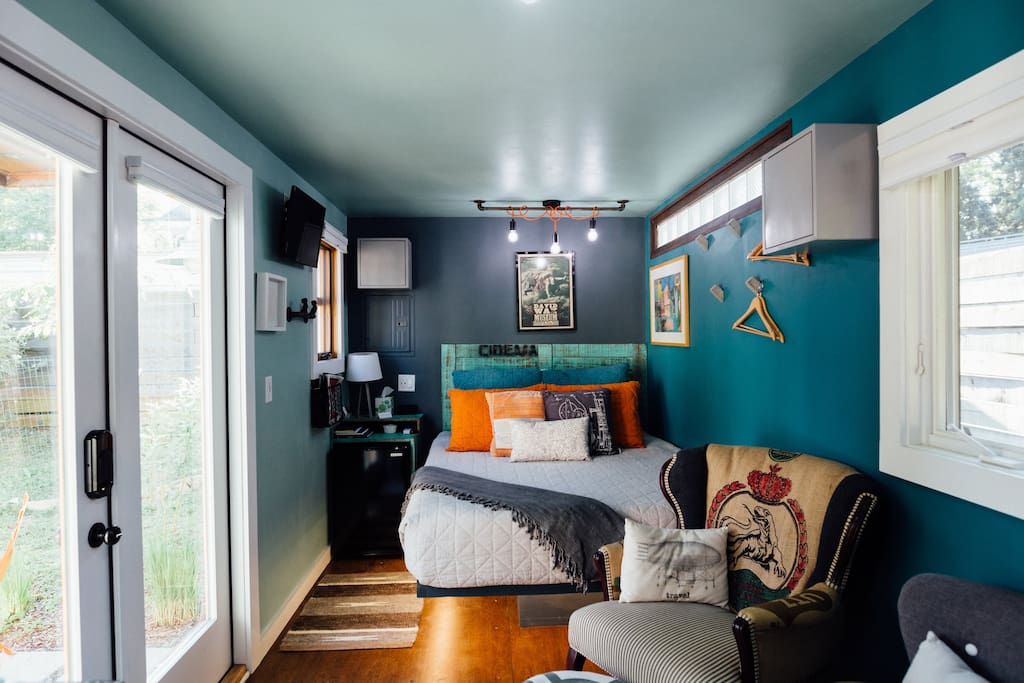 Headboard and nightstand / cubbies built from repurposed wood from Brazilian pallets, mini-fridge sits inside with storage cubbies around.