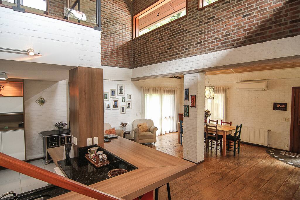 a cozinha com o fogão a lenha e a sala de jantar ao fundos com mesa para 08 pessoas