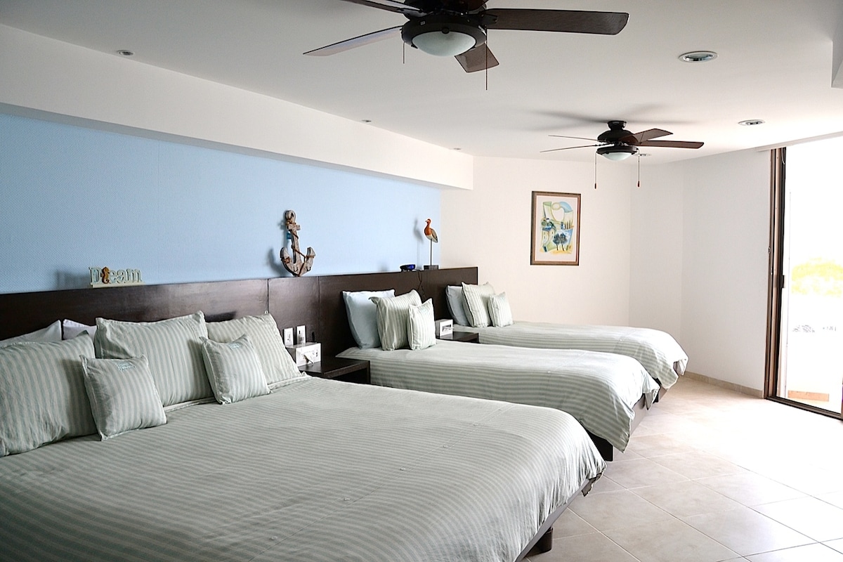 Dormitorio junto a la laguna con cama tamaño king, 2 camas individuales y balcón con vistas a la laguna.