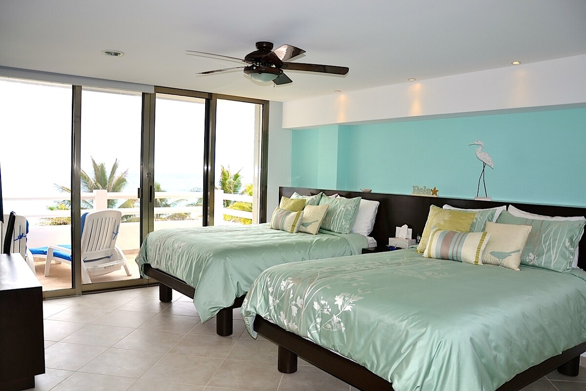 Dormitorio junto al mar con 2 camas tamaño queen y balcón.