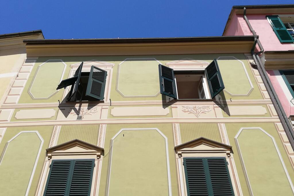 The two open windows of the flat in the sunshine