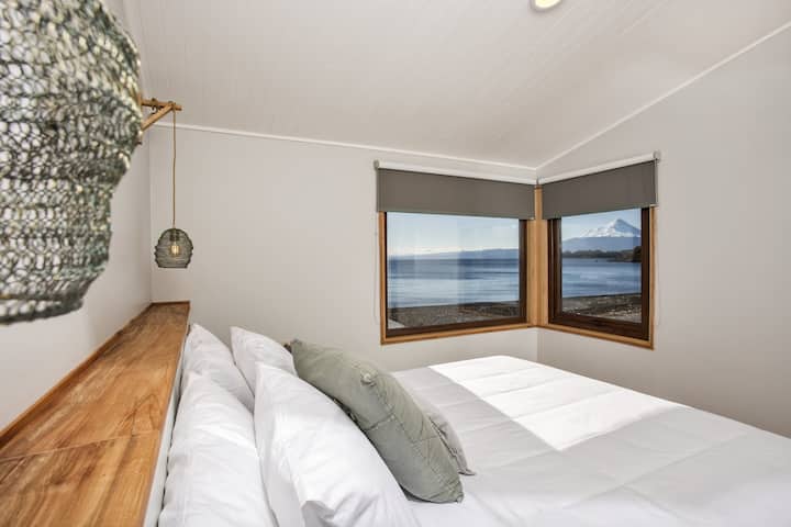 Master bedroom with a king-size bed and stunning lake and volcano views.