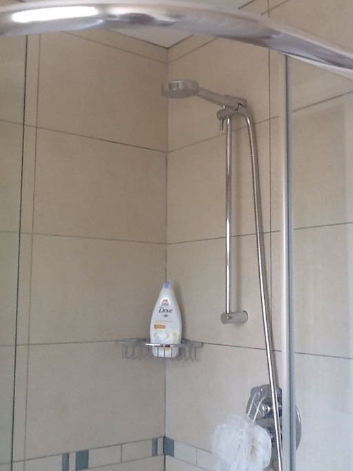 Fully tiled bathroom with modern shower cubicle and powerful shower.