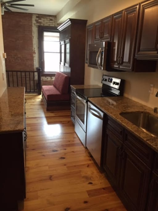 Granite countertops and new appliances. Plenty of space for the cook!
Queen size springloaded Murphy bed (shown in the up position with cushioned loveseat demonstrated) that also doubles as seating!