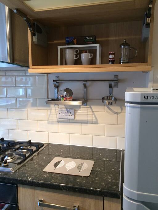 Kitchen with Fridge/ freezer with essential kitchen ware for tea/ coffee + breakfast - kettle / wine glasses /mugs / juice glasses/ bowls and plates provided.