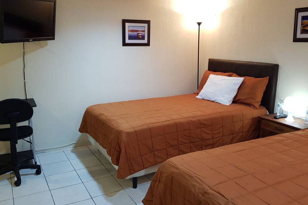 Espacio amplio entre camas, pasillo y baño.