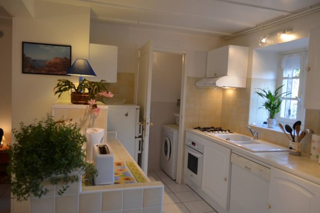 Cuisine US, petite buanderie en fond avec lave linge