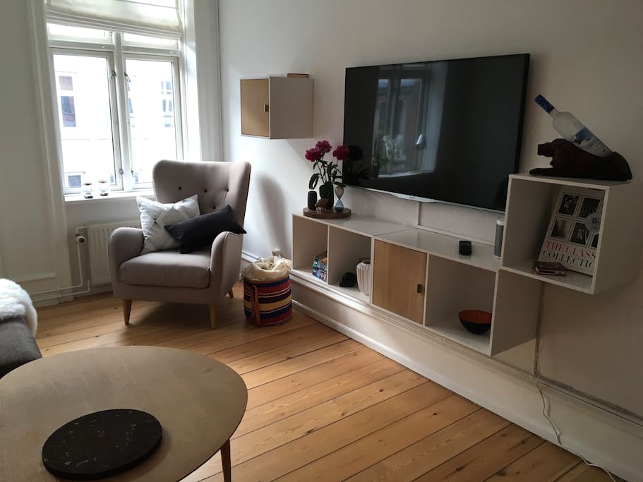 Spacious living room with lots of natural light – cozy reading corner and 50" TV