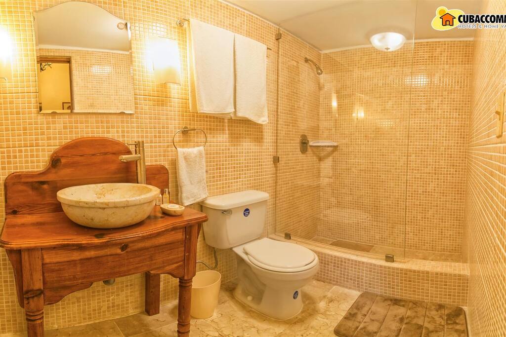 Baño equipado con secadora de pelo, agua fría y caliente y artículos de aseo