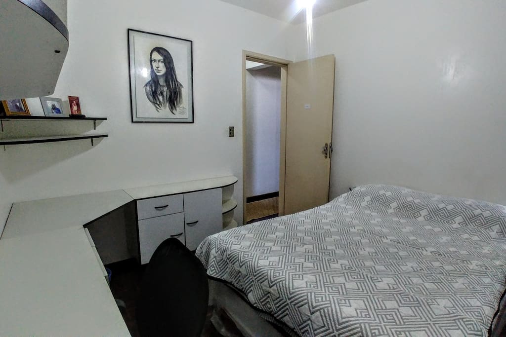 Quarto com cama de casal e escrivaninha