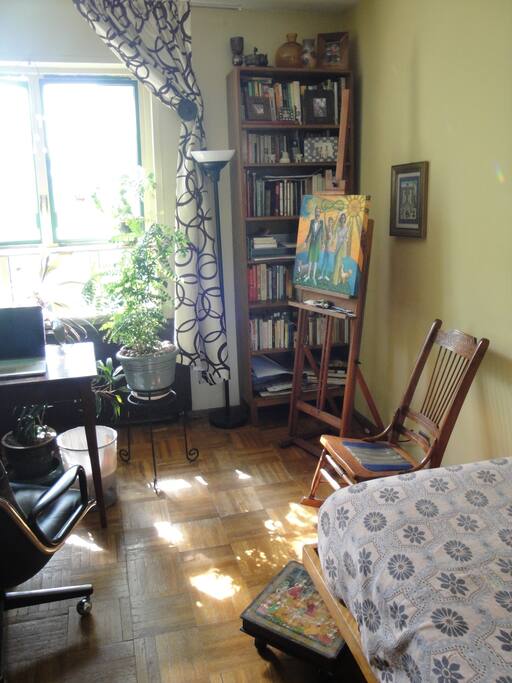 Sunny private room with work table and dresser.