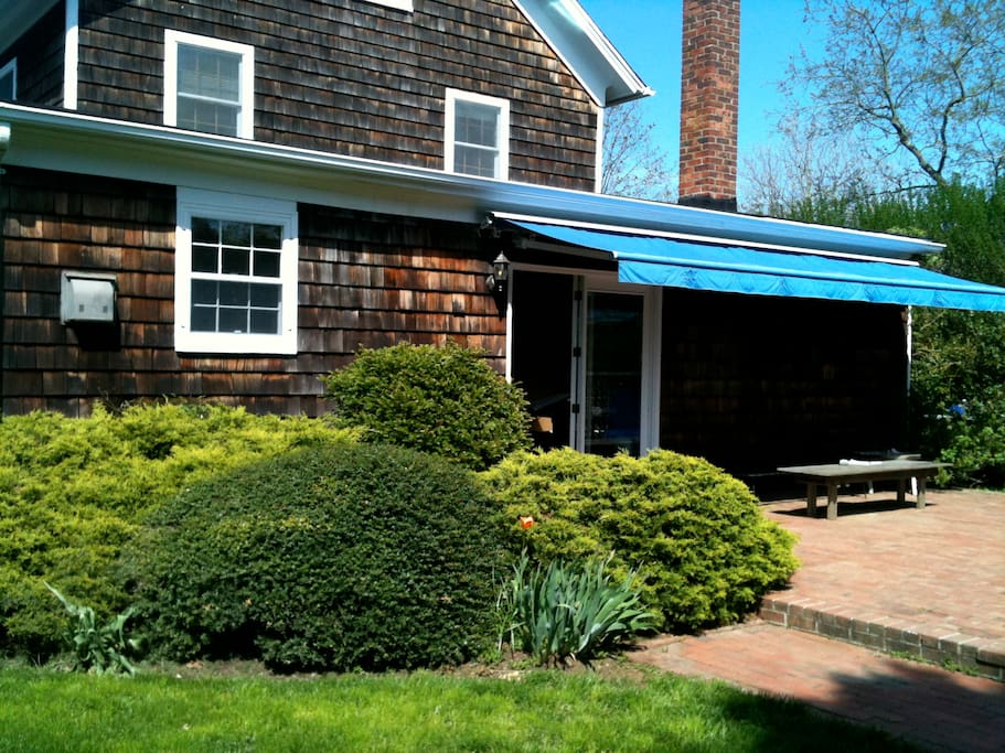 Brick terrace with awning for shade.