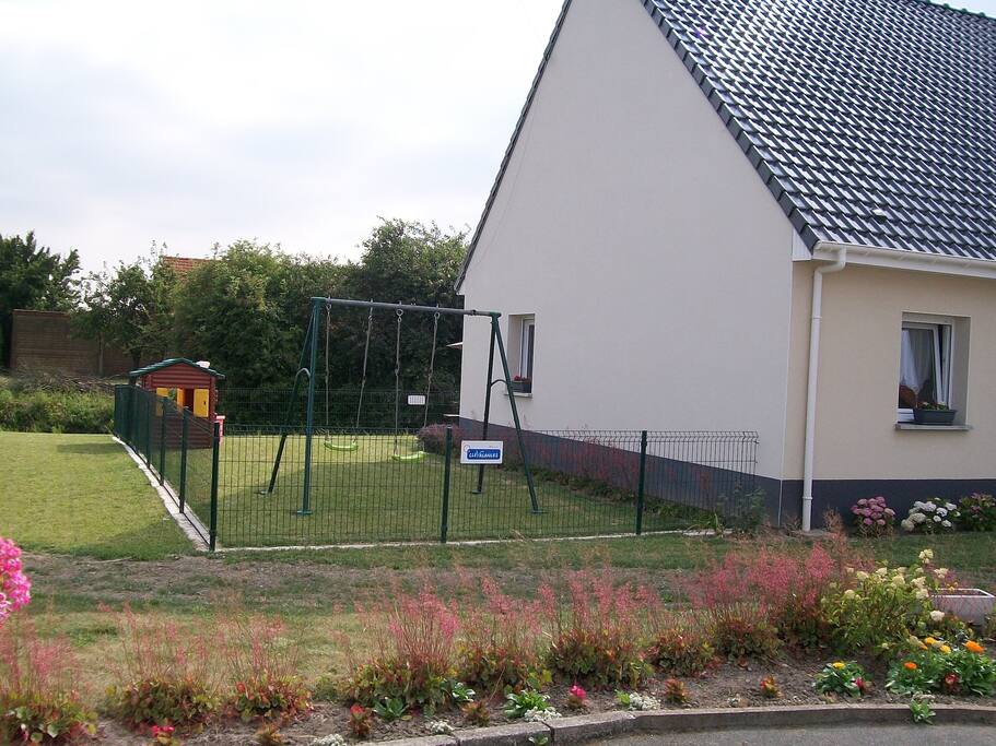Jardin clôturé avec balançoire et cabane du trappeur