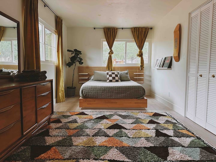 Dormitorio 2, completo con cama tamaño queen, mucha luz hermosa con vistas al patio trasero y acantilados rojos, y mucho espacio de almacenamiento.