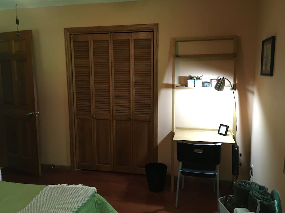 Desk and large closet with hangers.