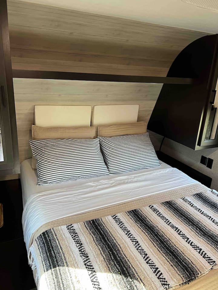 Main bedroom has queen bed with bedside tables and closet