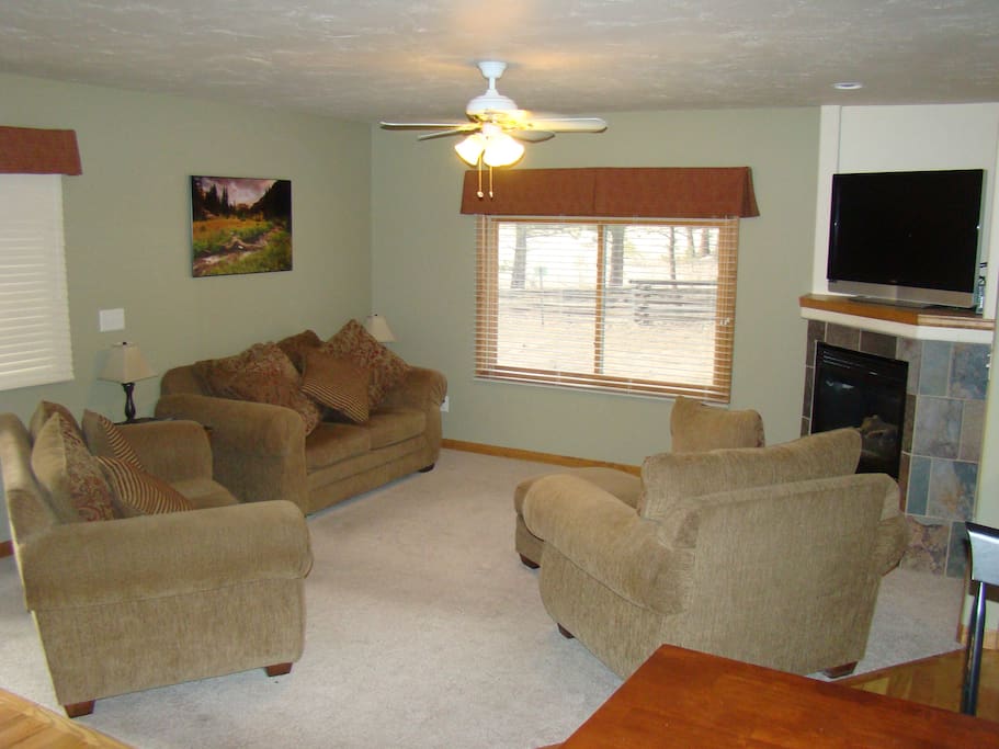 Spacious living room with flatscreen satellite TV and fireplace.