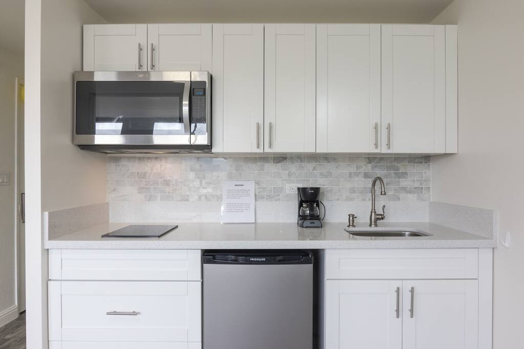Appliances include toaster, blender, coffee maker, kettle, induction cooktop and full functioning over the range microwave