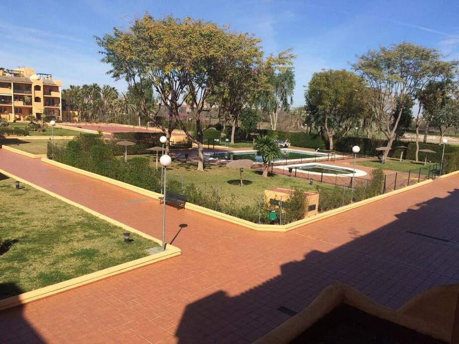 Amplias zonas verdes, piscina y pista de tennis.