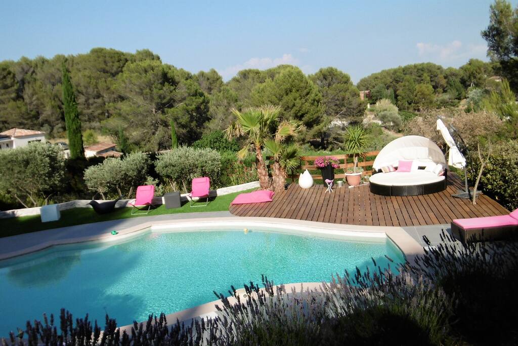 plage de la piscine équipée de transats, parasols et douche extérieure