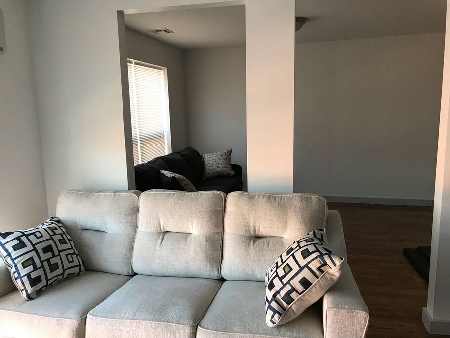 Solo dark grey couch behind Cream couch for Coverts to queen size bed.