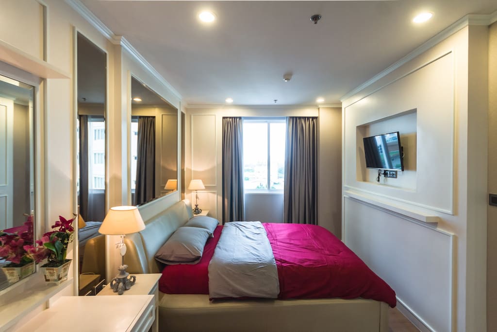 Bedroom for two with TV, wardrobe, and vanity desk.