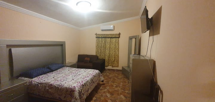 غرفة النوم الرئيسية التي تحتوي على تلفزيون ذكي 32 بوصة، ونيفليكس، وخزانة صغيرة وخزانة واسعة 