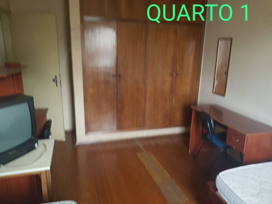 Quarto 1 - Possui 2 camas de solteiro, 2 escrivaninhas, 1 armário embutido de 4 portas, 1 espelho e 1 estante de aço