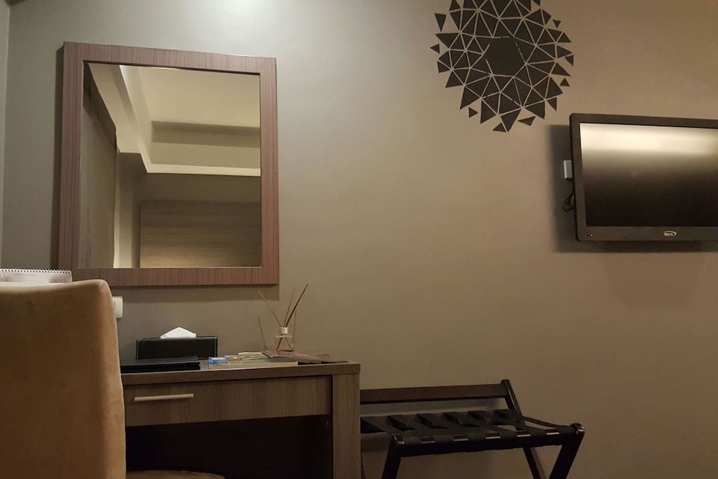 Dresser and television of room with double beds