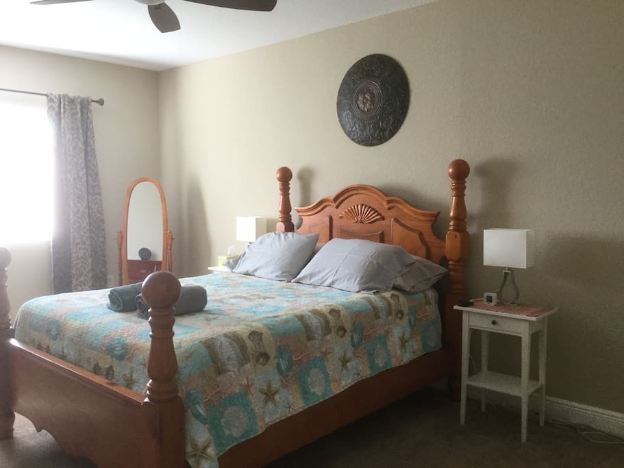 Big master bedroom with a queen bed, walk in closet and credenza.