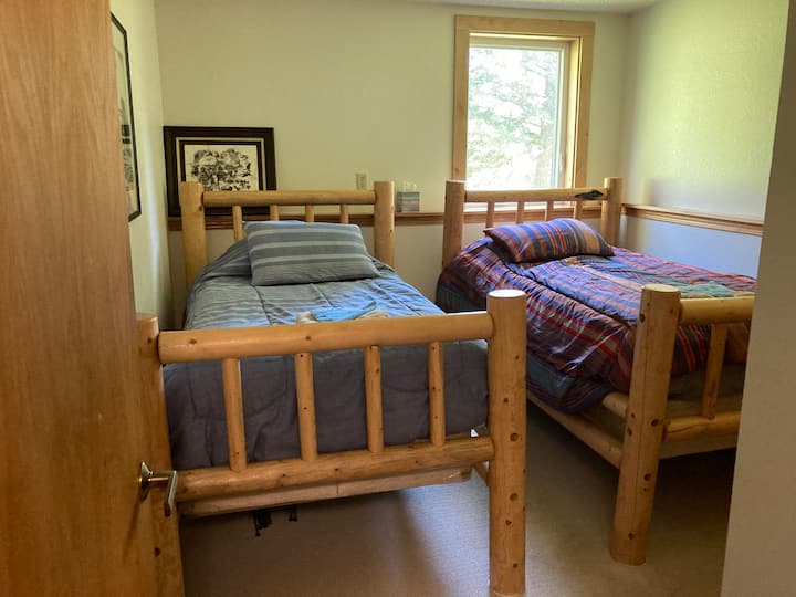 Spavaća soba nižeg nivoa s 2 odvojena kreveta i zajedničkim velikim kupatilom. 