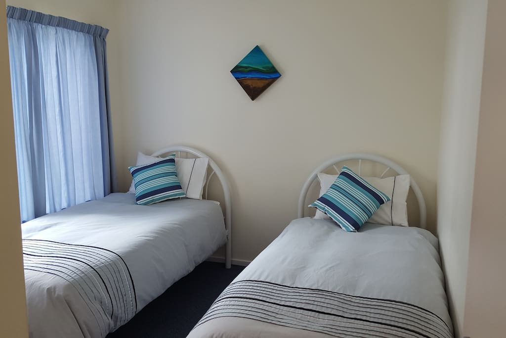 Two single beds in sunny second bedroom. Comfortable, spacious with quality bedding and linens.