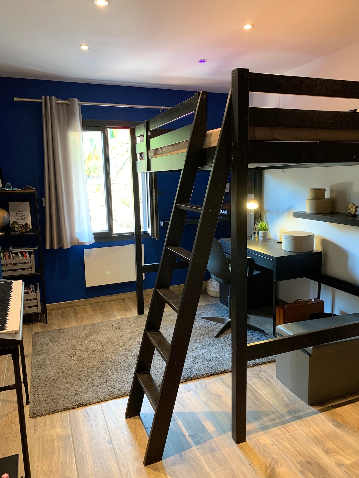 Спалня с двойно легло на мецанин и баня (на долния етаж). Изглед към басейна от малкия прозорец и достъп до фитнес залата през големия прозорец 