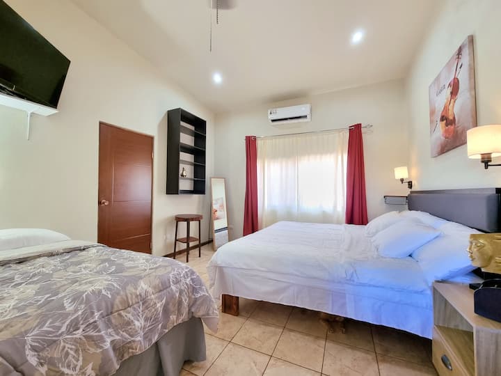 Main room with its own bathroom, Tv, king bed, single bed and A/C