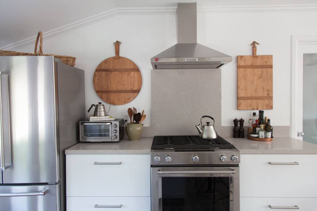 Full size refrigerator and freezer, professional gas range and hood, large oven. Small appliances for food prep can be found in ample storage.